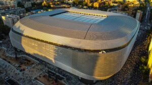 Aerial shot of Santiago Bernabéu Stadium in Madrid during sunset showcasing its modern architecture.